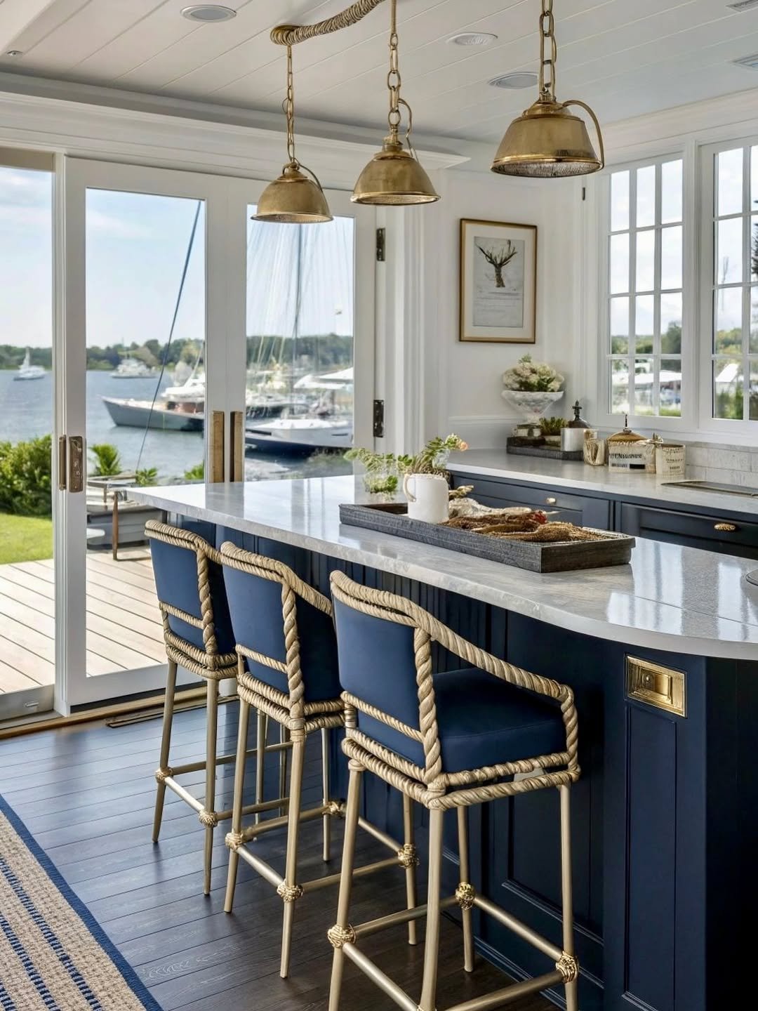Deep navy island with brass and rope barstool antique brass dome pendant and marble waterfall counter