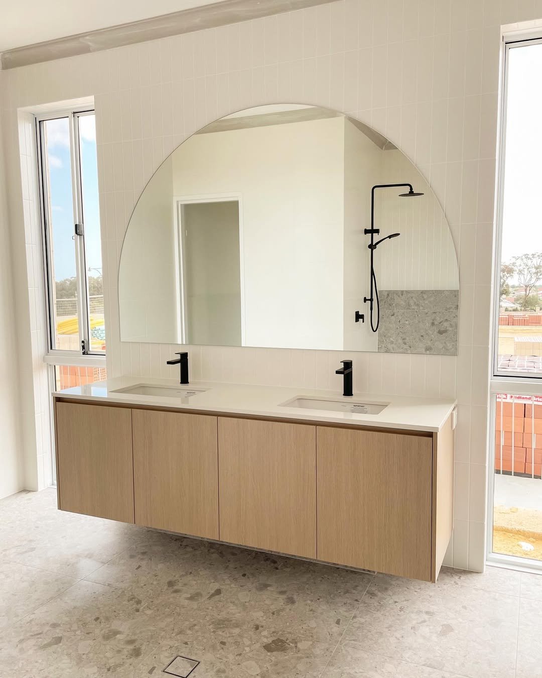 Frameless Arched Mirror Over a Floating Oak Vanity