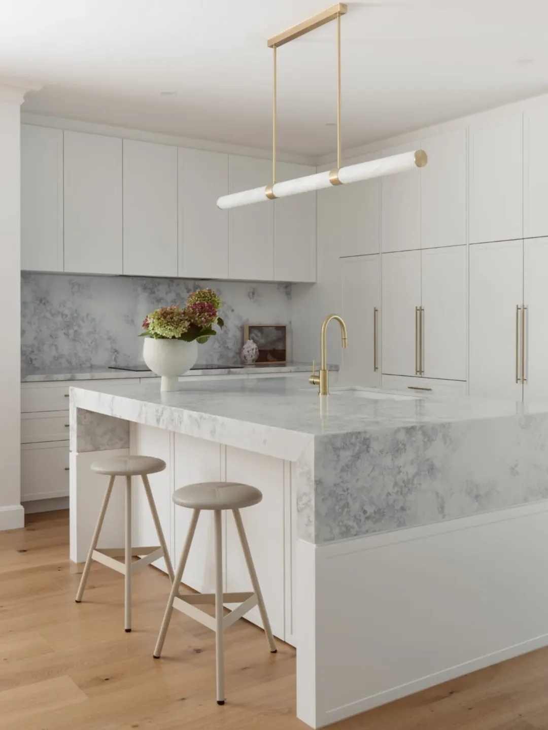 Kitchen scheme with one brass linear pendant and thick marble island