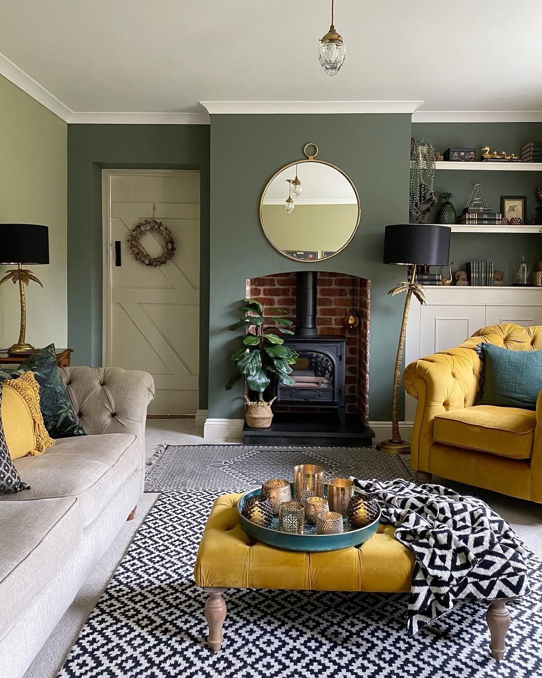 Living Room with Green Walls and a Round Brass Mirror