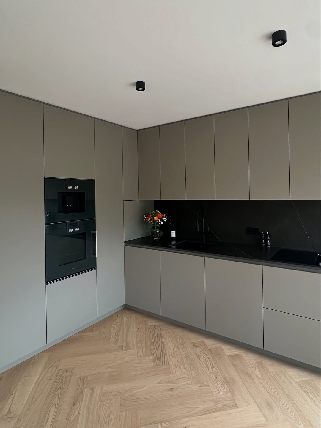 Taupe Matte Cabinetry, Black Stone, and Herringbone Parquet Kitchen