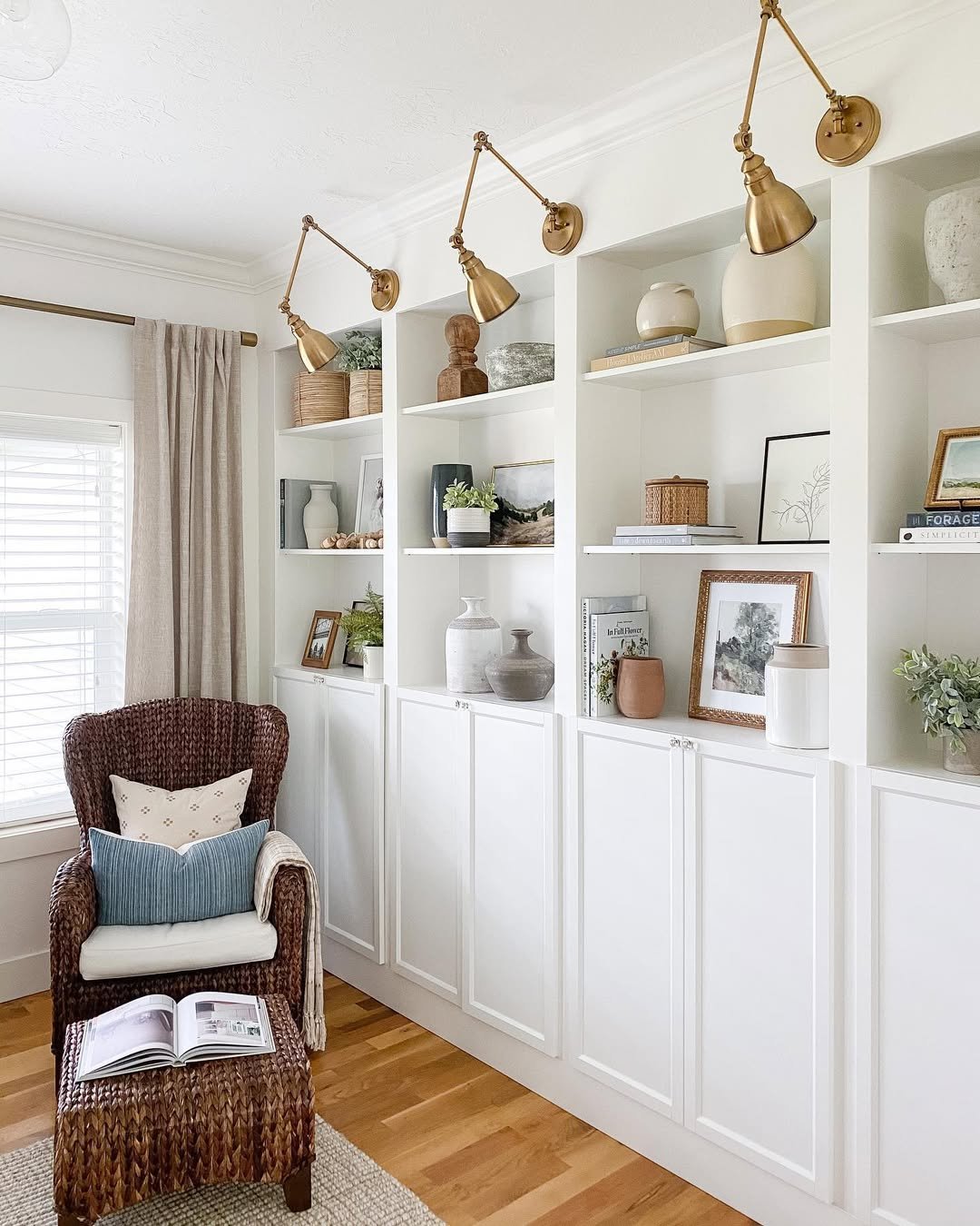 White Library Wall with Three Brass Swing-Arm Sconces